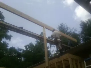 Carpenter setting a ridge beam over a new addition frame — Ice Dam Removal by Roofing Brothers in Speer