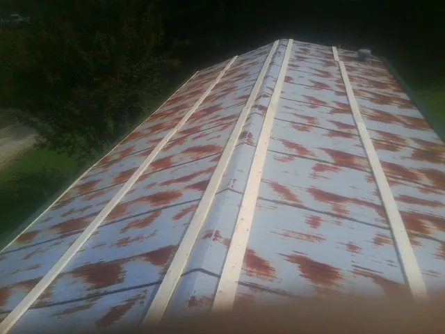 Rusted metal roof panels with new wood purlins before replacement — Storm Damage Roof Repair in Speer by Roofing Brothers