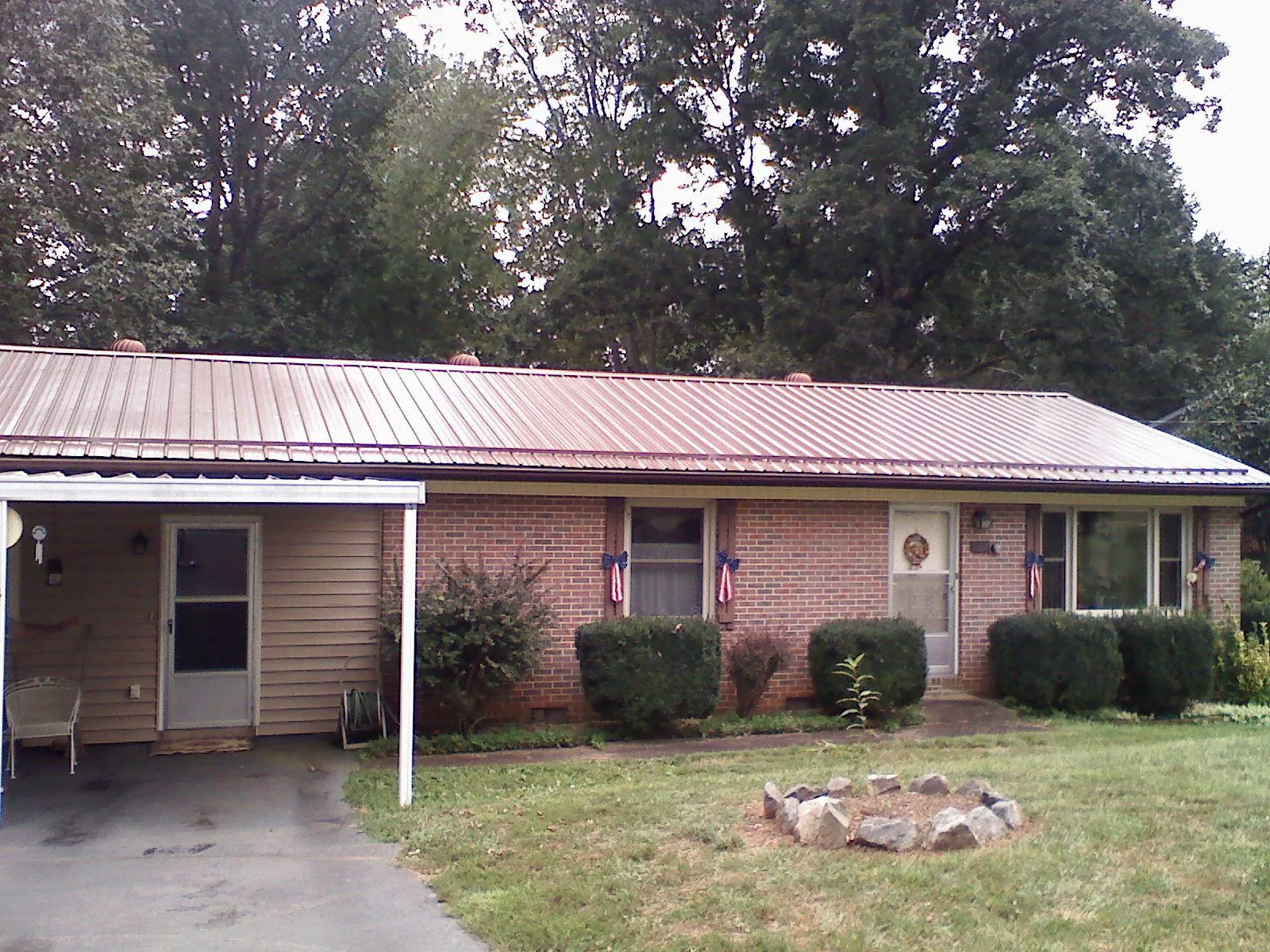 Bronze metal roof and carport on a brick ranch home — Roof Repair work by our crew in Speer